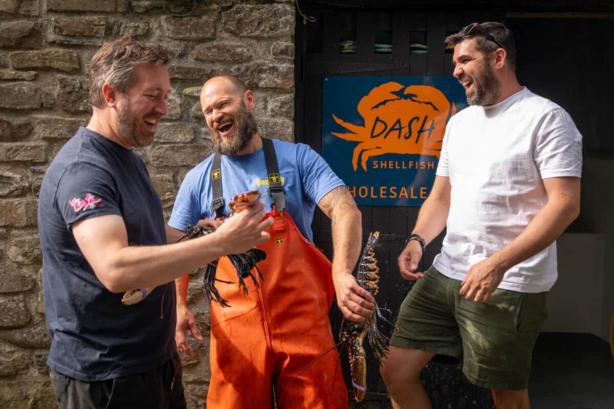 Anthony, Dan and Danny laughing together holding some lobsters
