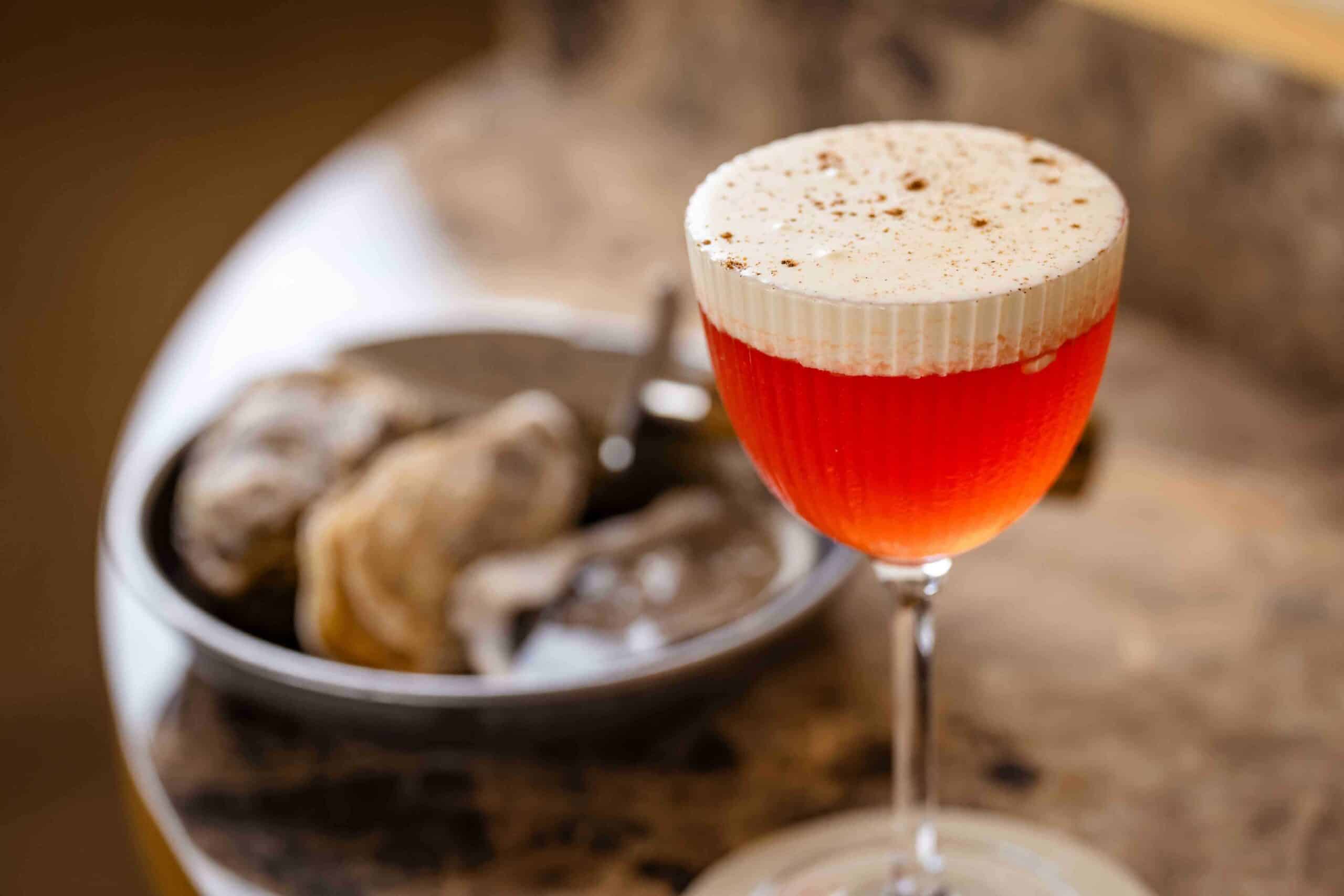 A cocktail and some oysters blurred in the background