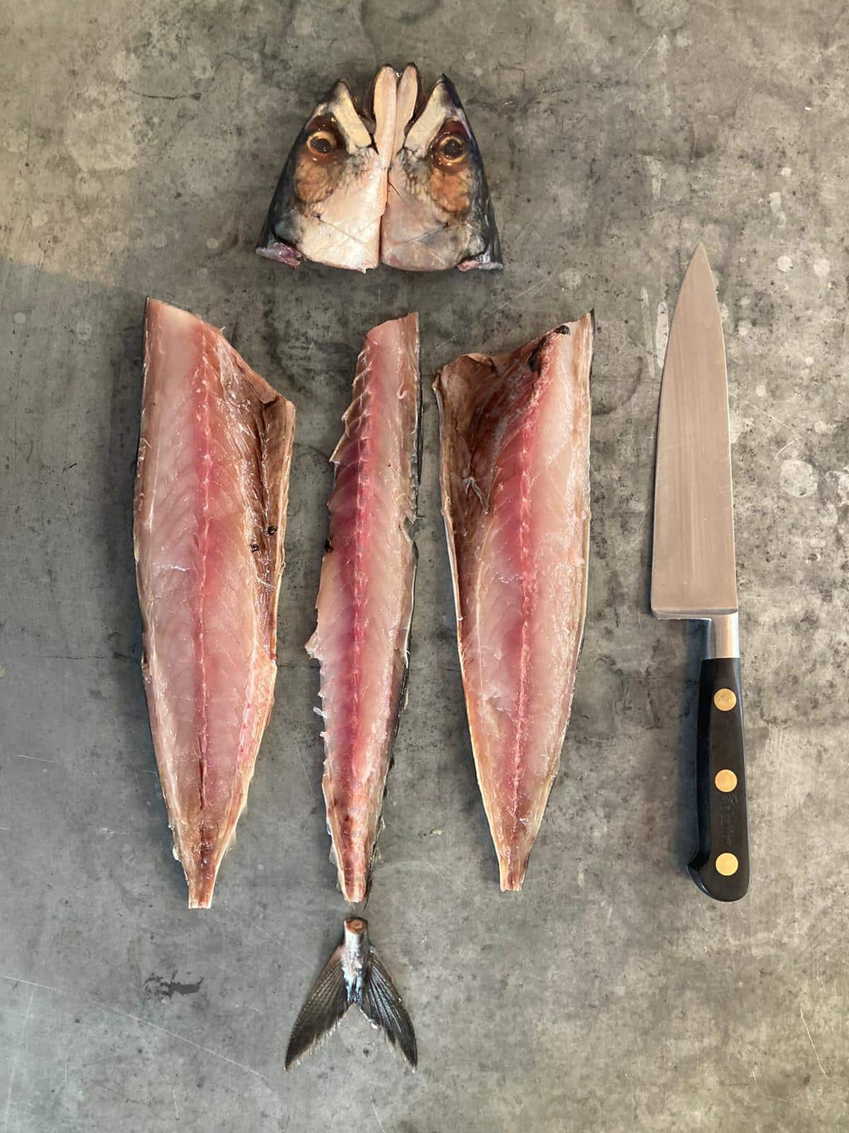 Filleted & quartered fish on a nickel service with filleting knifee to side